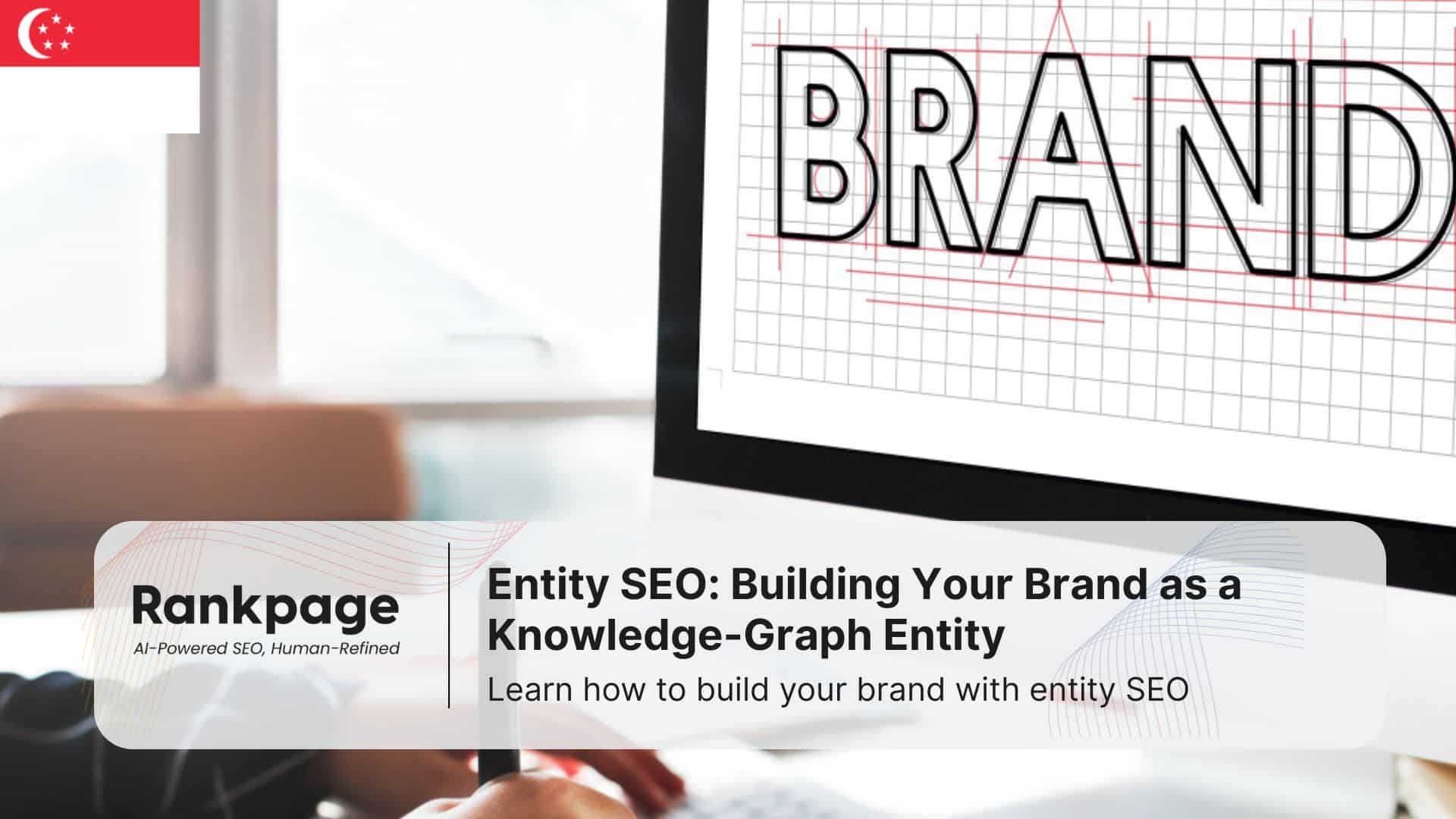 Photo of a man working at a PC with the word 'brand' on the screen, representing entity SEO
